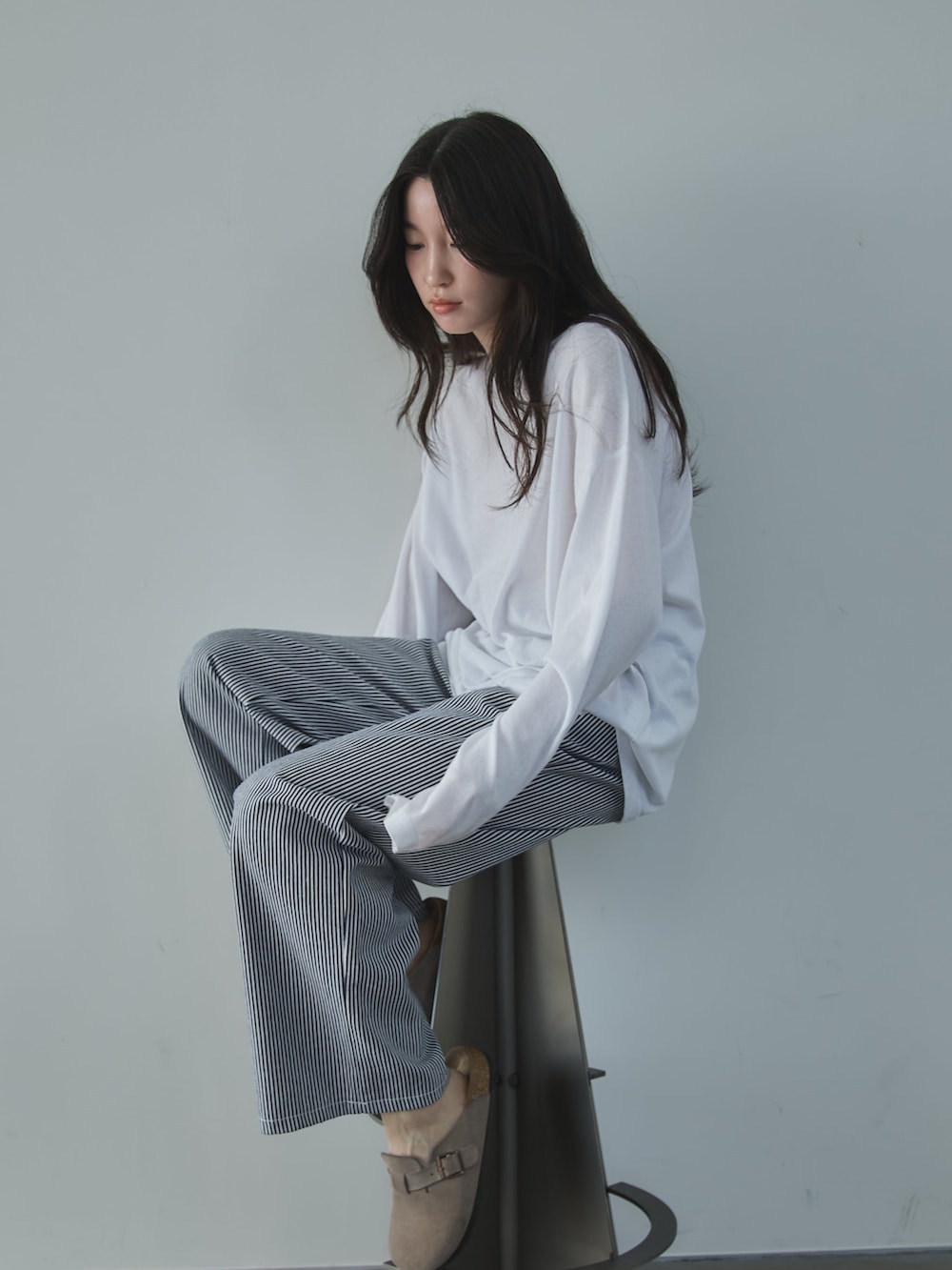 ホワイト系のTシャツ/カットソー、ホワイト系のデニムパンツ、ベージュ系のサンダルを着用したレディースの冬コーディネートの3枚目の写真