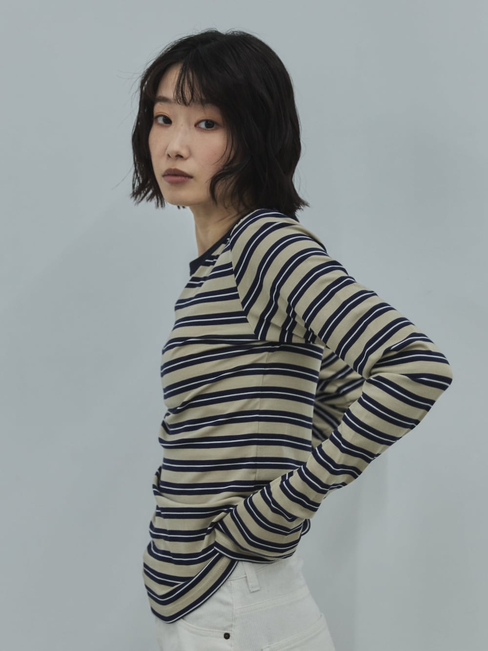 ベージュ系のTシャツ/カットソー、ホワイト系のデニムパンツ、ブラック系のローファーを着用したレディースの秋コーディネートの4枚目の写真