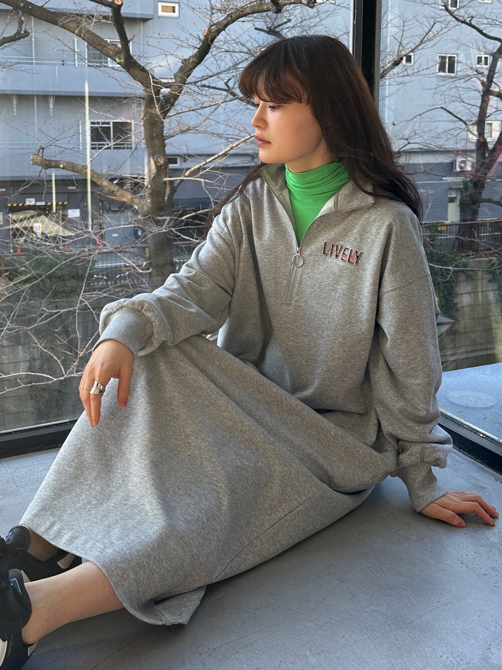 グレー系のワンピース、ブラック系のスニーカー、ベージュ系のワンピースを着用したレディースの冬コーディネートの3枚目の写真