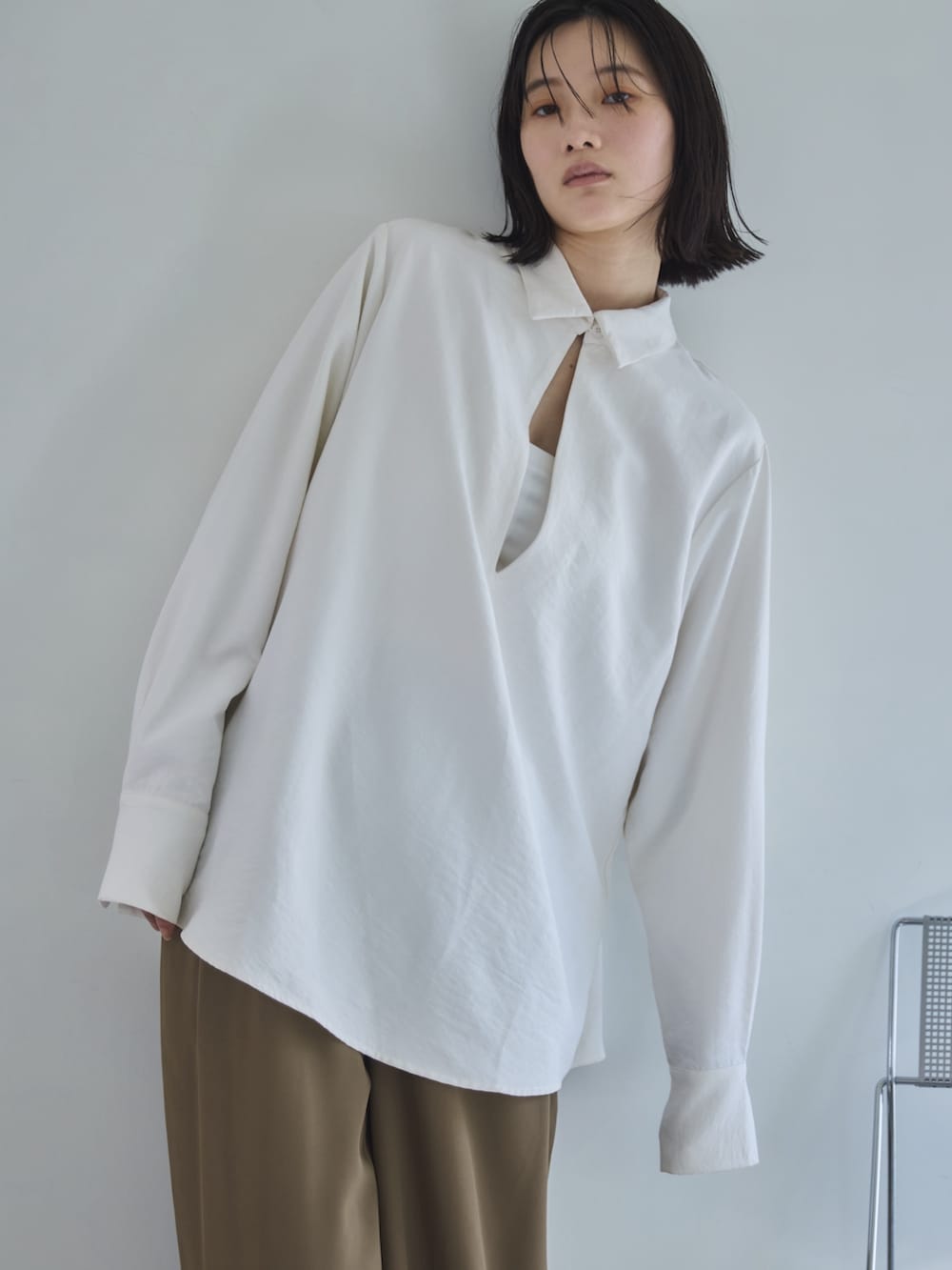 ホワイト系のシャツ/ブラウス、ベージュ系のスラックス、ブラック系のスリッポンを着用したレディースの春コーディネートの3枚目の写真