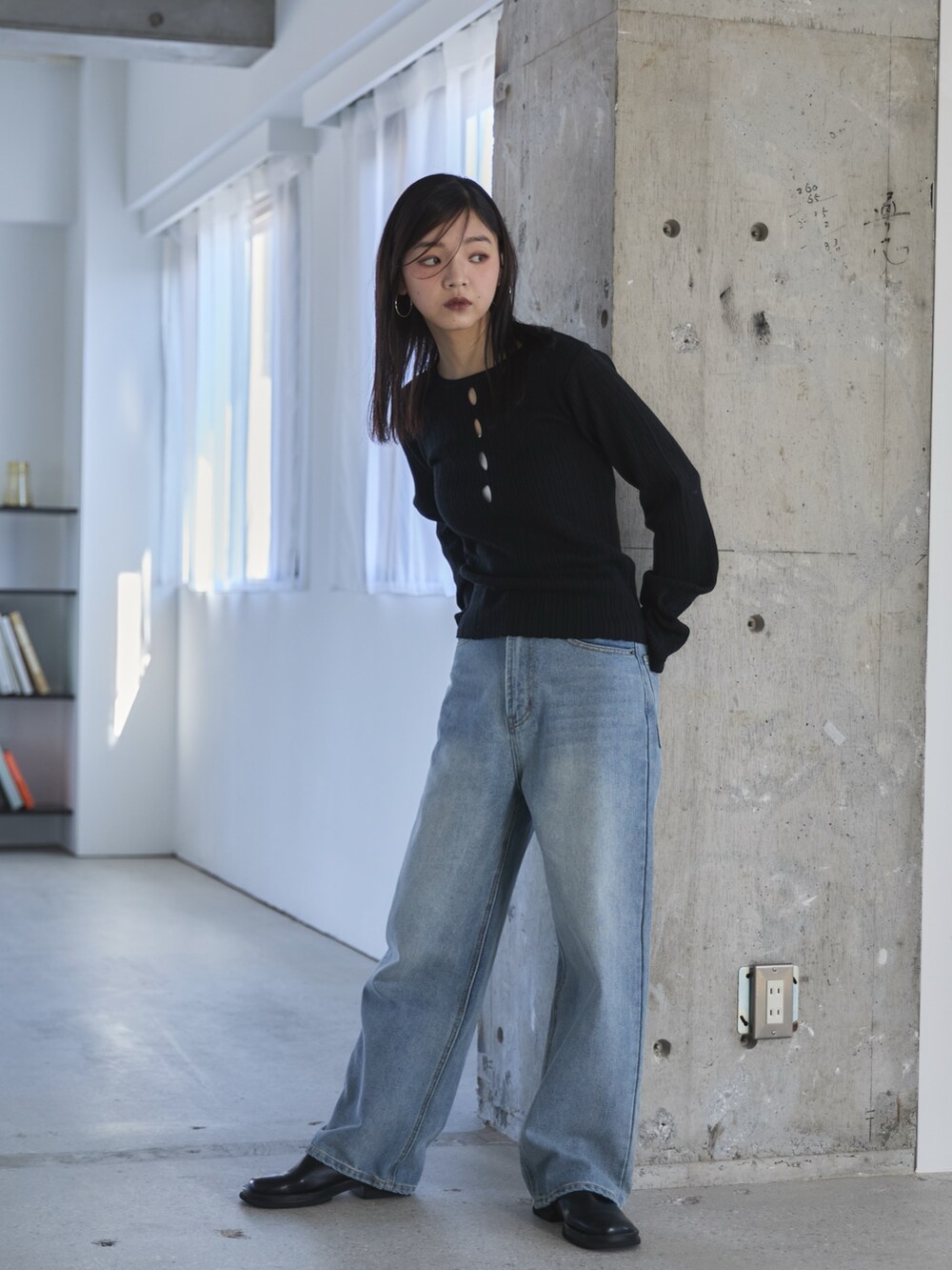 ブラック系のニット/セーター、ブラック系のスリッポン、ブルー系のデニムパンツを着用したレディースの冬コーディネートの3枚目の写真