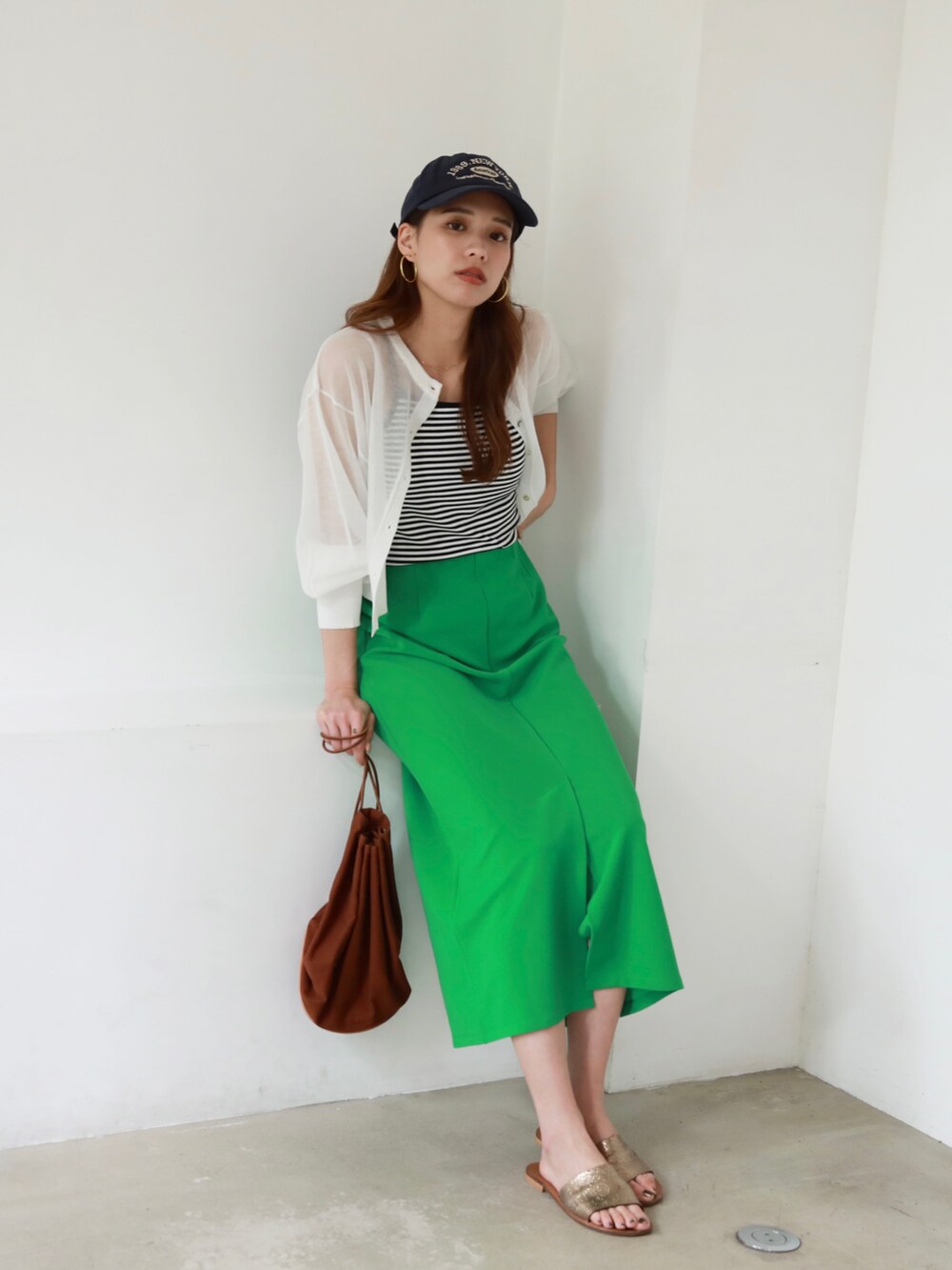 グリーン系のスカート、ホワイト系のTシャツ/カットソー、その他のサングラスを着用したレディースの夏コーディネートの5枚目の写真