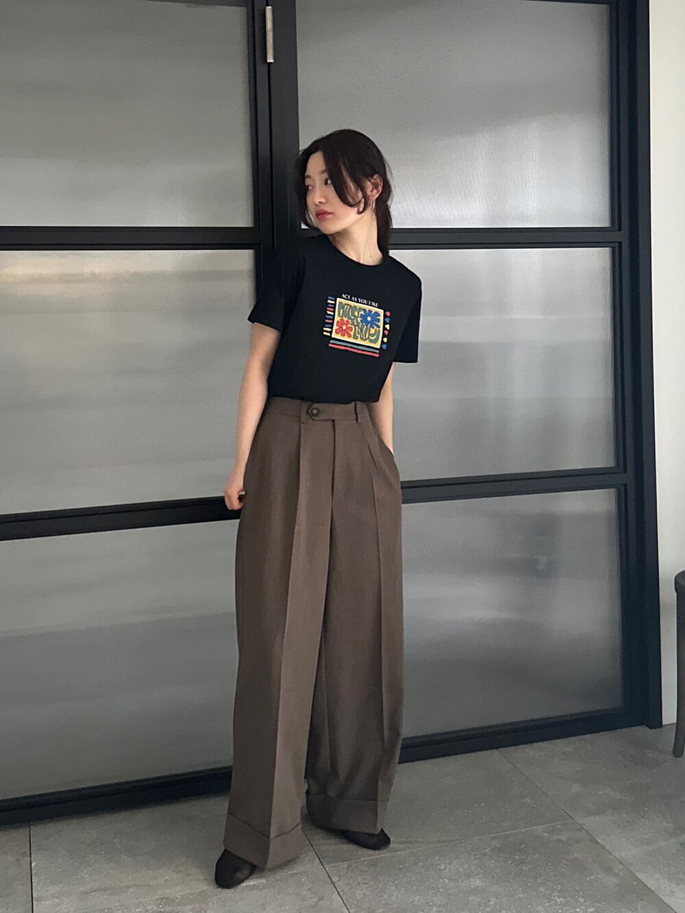 ブラック系のTシャツ/カットソー、ブラウン系のスラックス、ベージュ系のその他シューズを着用したレディースの春コーディネートの2枚目の写真