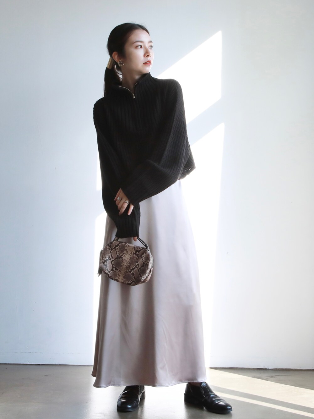 ホワイト系のニット/セーター、ブラック系のその他パンツ、ブラック系のハンドバッグを着用したレディースの冬コーディネートの4枚目の写真