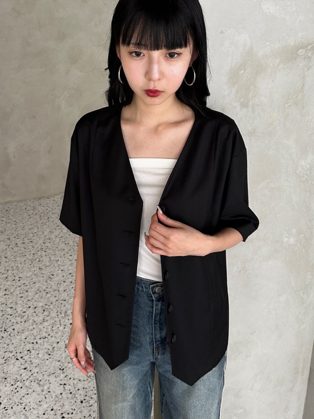 ブルー系のデニムパンツ、ブラック系のサンダル、ブラック系のノーカラージャケットを着用したレディースの夏コーディネートの3枚目の写真