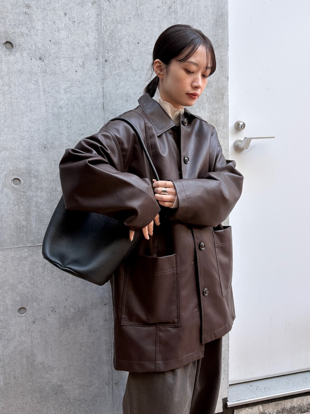 ブラウン系のカバーオール、ホワイト系のカーディガン/ボレロ、ブラック系のショルダーバッグを着用したレディースの春コーディネートの4枚目の写真