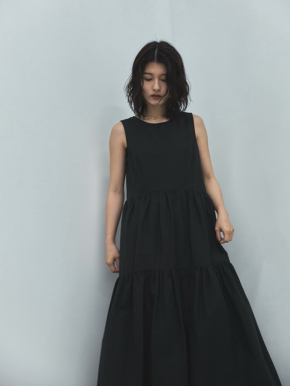 ブラック系のワンピース、ブラック系のサンダル、ゴールド系のネックレスを着用したレディースの夏コーディネートの3枚目の写真