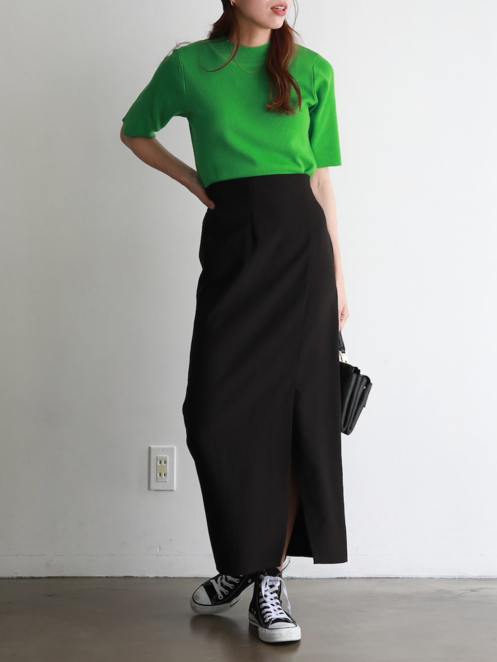 ブラック系のスニーカー、ブラック系のスカート、ブラック系のショルダーバッグを着用したレディースの春コーディネートの3枚目の写真