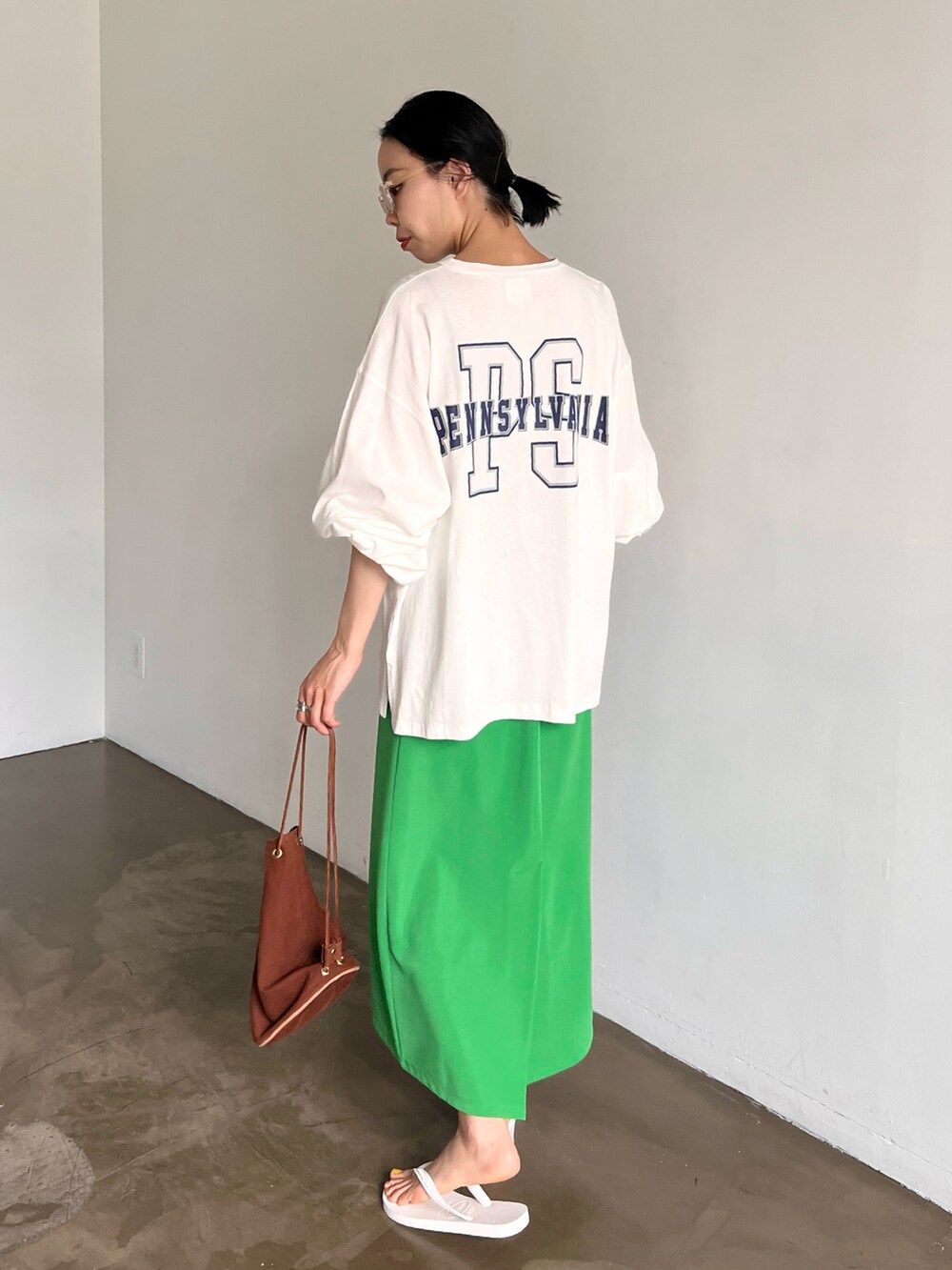 グリーン系のスカート、ホワイト系のTシャツ/カットソー、その他のサングラスを着用したレディースの夏コーディネートの2枚目の写真