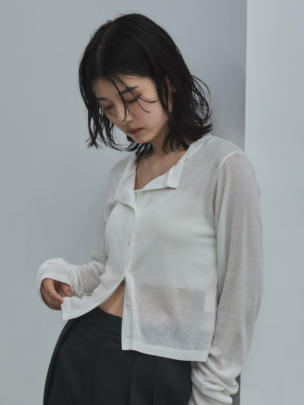 ホワイト系のカーディガン/ボレロ、グレー系のスラックス、ブラック系のローファーを着用したレディースの夏コーディネートの5枚目の写真