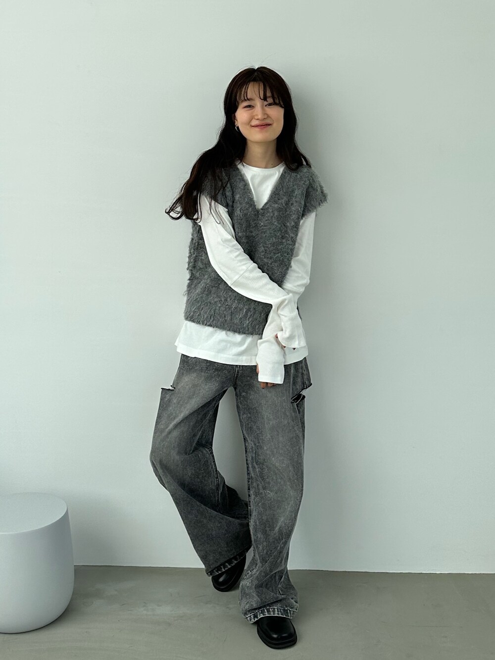グレー系のベスト、ブラック系のデニムパンツ、その他のその他を着用したレディースの秋コーディネートの3枚目の写真