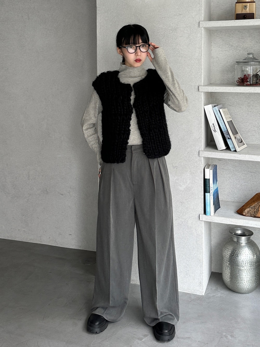 グレー系のニット/セーター、ブラック系のベスト、グレー系のスラックスを着用したレディースの冬コーディネートの3枚目の写真