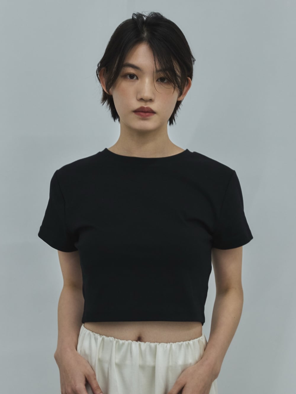 ブラック系のTシャツ/カットソー、ホワイト系のスカート、ブラック系のサンダルを着用したレディースの夏コーディネートの4枚目の写真