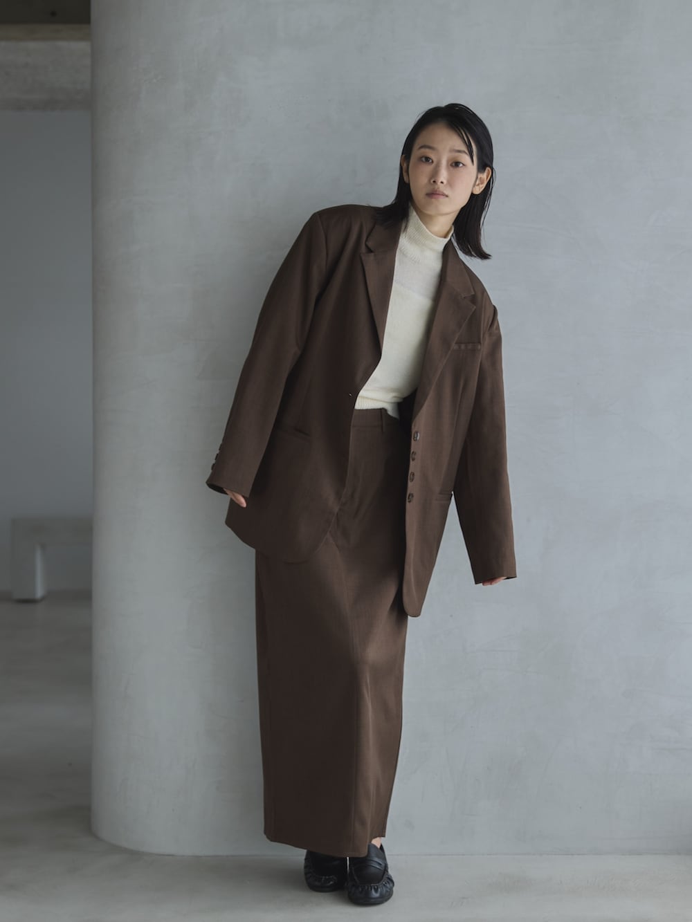 ホワイト系のデニムパンツ、ホワイト系のTシャツ/カットソー、ブラウン系のテーラードジャケットを着用したレディースの秋コーディネートの6枚目の写真