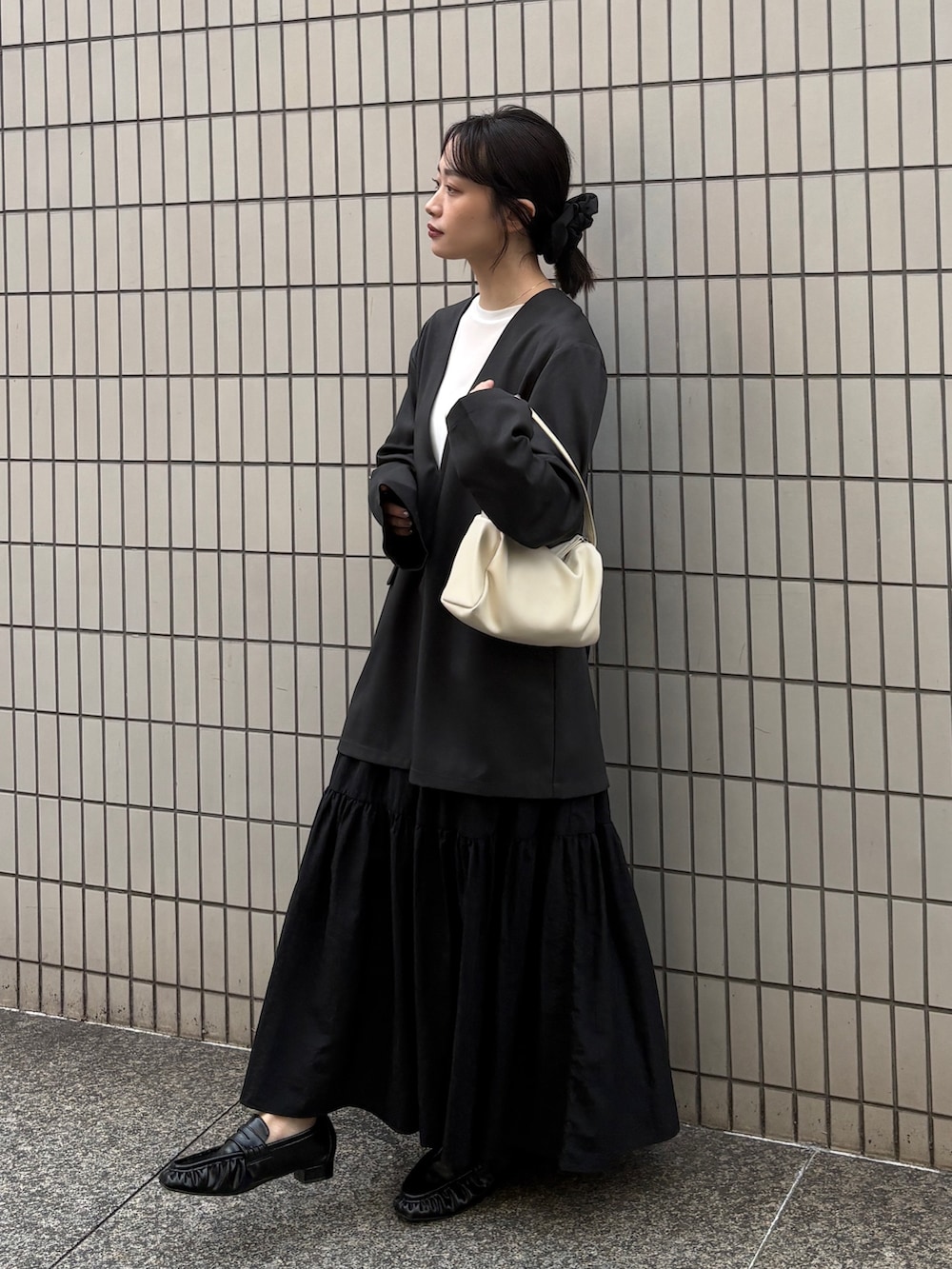 グレー系のその他トップス、ホワイト系のTシャツ/カットソー、ブラック系のスカートを着用したレディースの春コーディネートの2枚目の写真