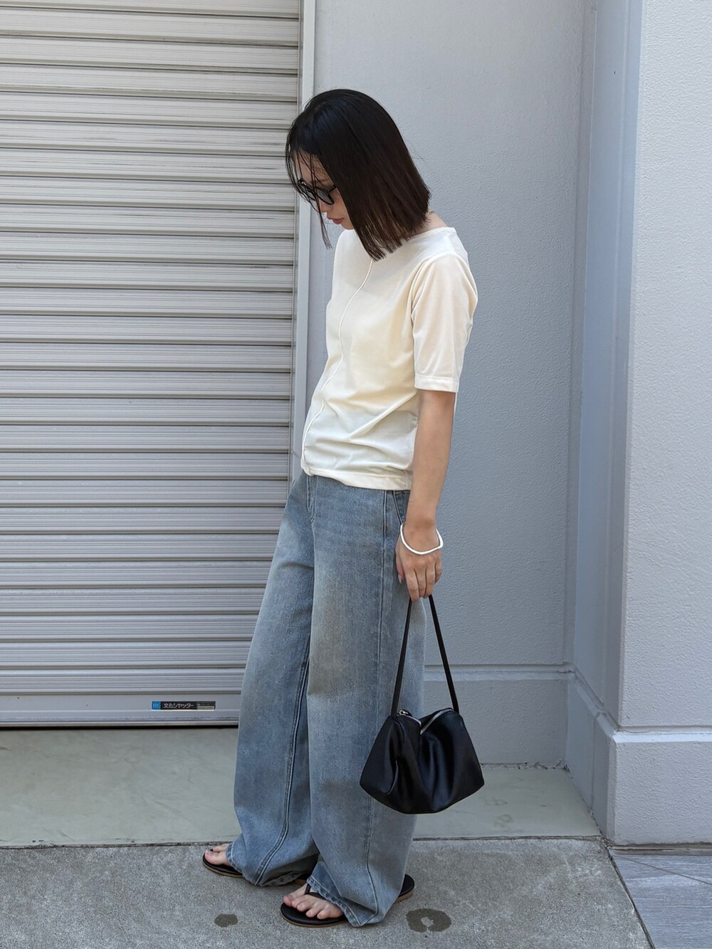 ホワイト系のTシャツ/カットソー、ブラック系のショルダーバッグ、ブルー系のデニムパンツを着用したレディースの夏コーディネートの2枚目の写真