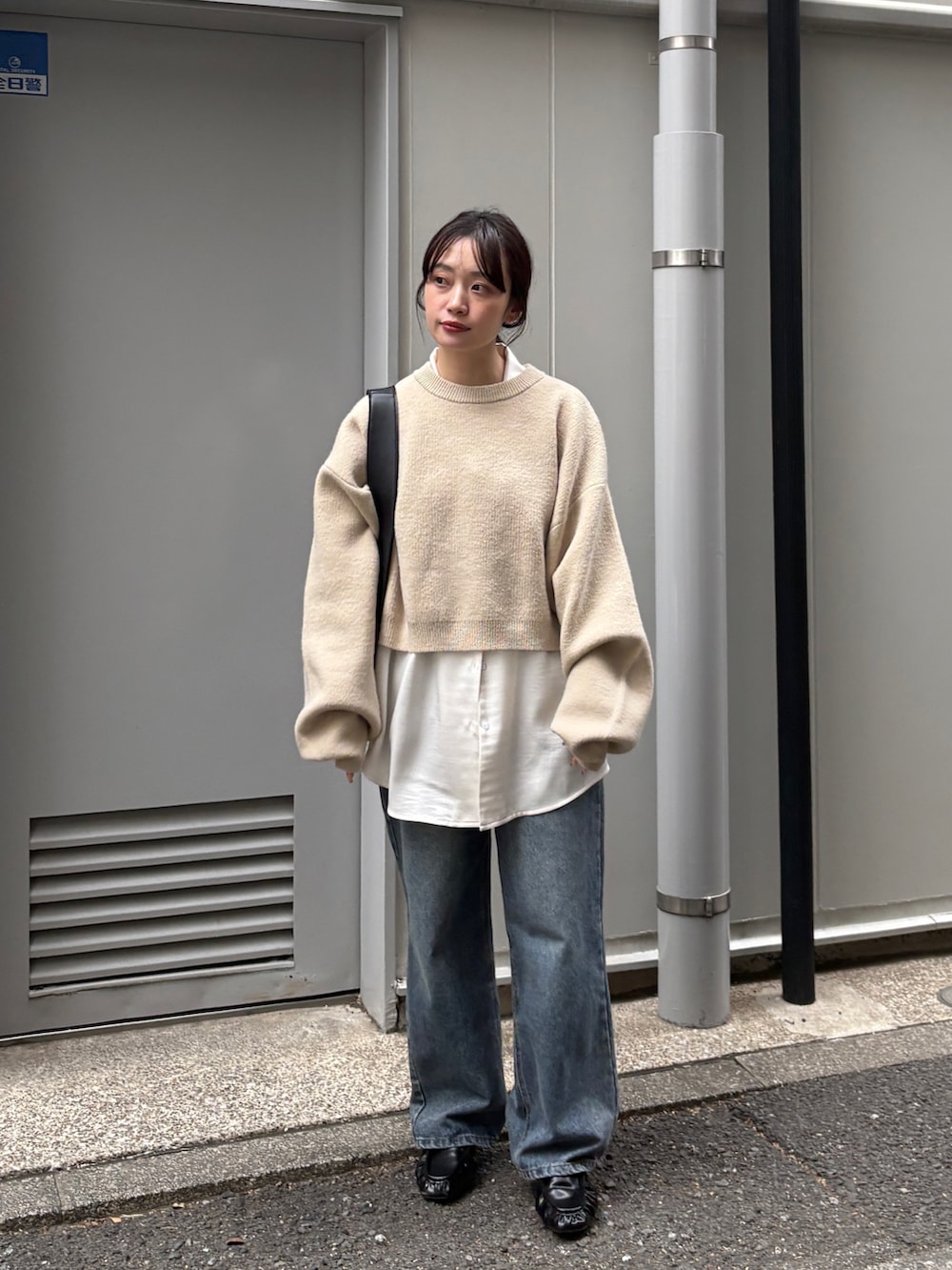 ベージュ系のニット/セーター、ホワイト系のシャツ/ブラウス、ブルー系のデニムパンツを着用したレディースの冬コーディネートの2枚目の写真