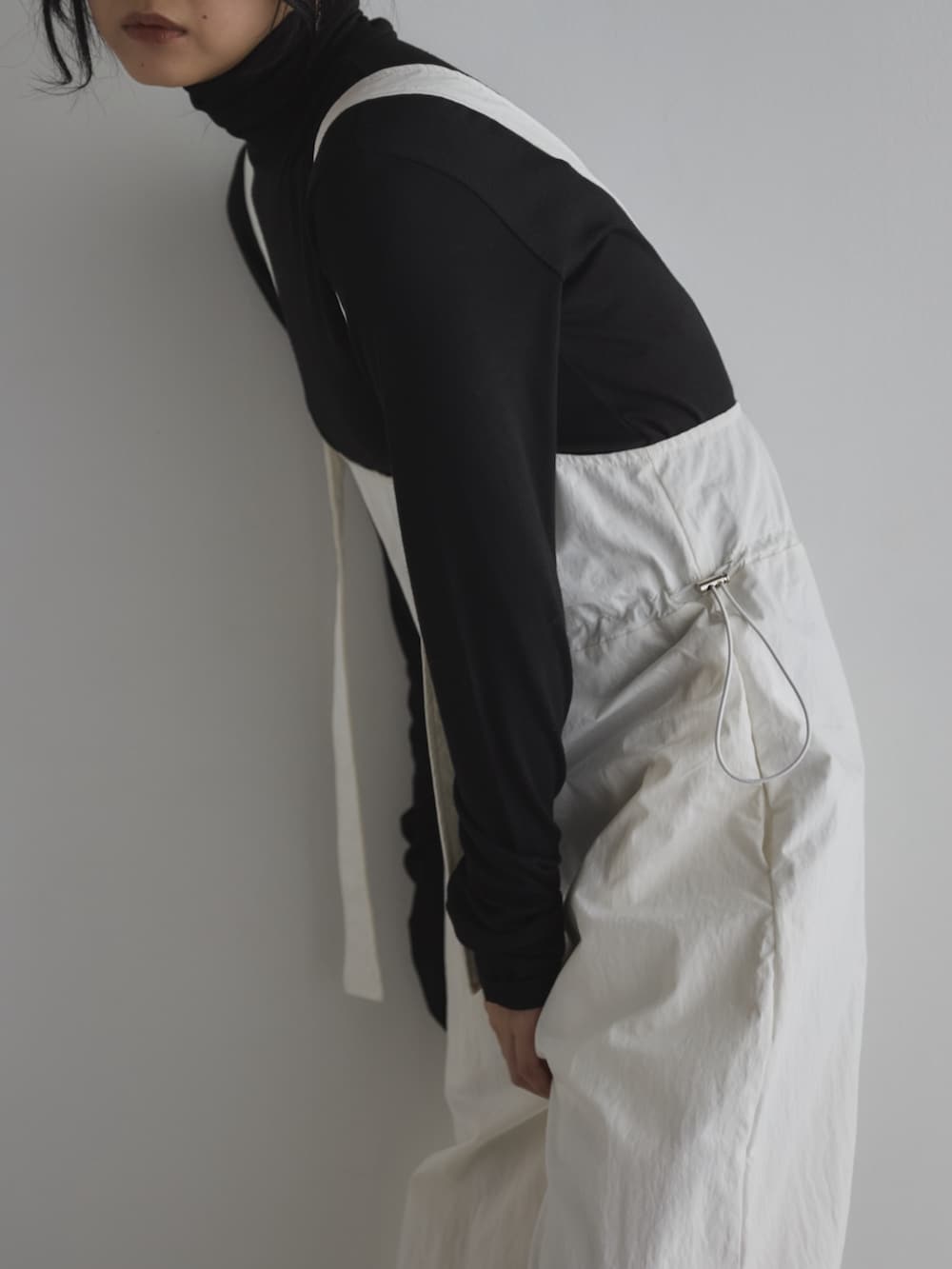 ブラック系のTシャツ/カットソー、ブラック系のサンダル、ホワイト系のサロペット/オーバーオールを着用したレディースの春コーディネートの4枚目の写真