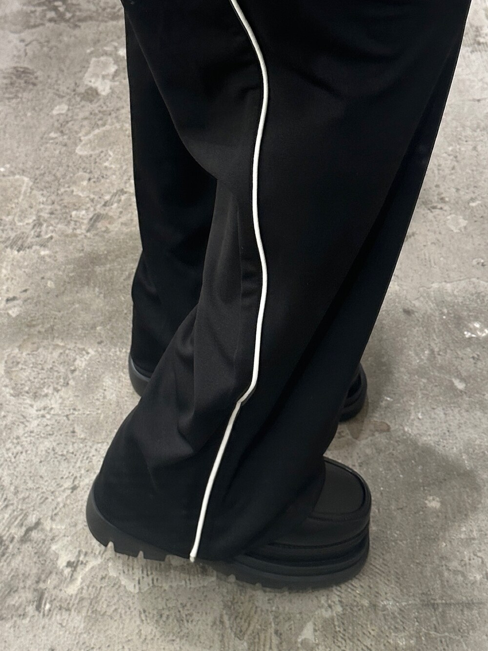 ブラック系のスラックス、ブラック系のニット/セーター、ブラック系のローファーを着用したレディースの冬コーディネートの5枚目の写真