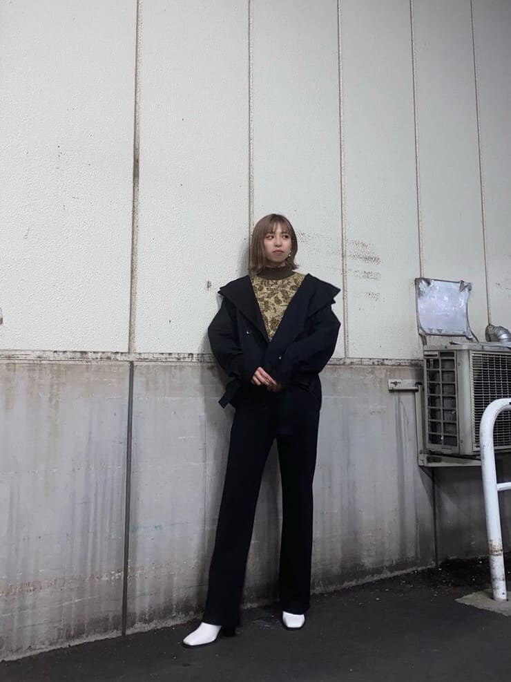 ブラック系のトレンチコート、ブラック系のその他パンツ、ホワイト系のブーツを着用したレディースの冬コーディネートの2枚目の写真