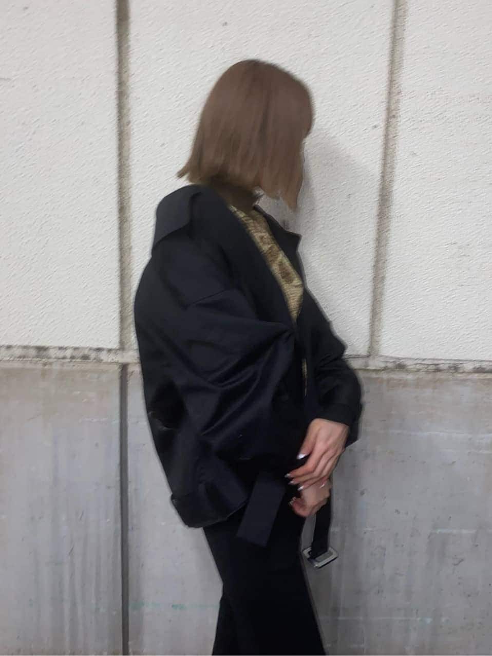 ブラック系のトレンチコート、ブラック系のその他パンツ、ホワイト系のブーツを着用したレディースの冬コーディネートの3枚目の写真