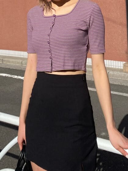 ブラック系のスカート、ブラック系のスニーカー、イエロー系のショルダーバッグを着用したレディースの春コーディネートの2枚目の写真