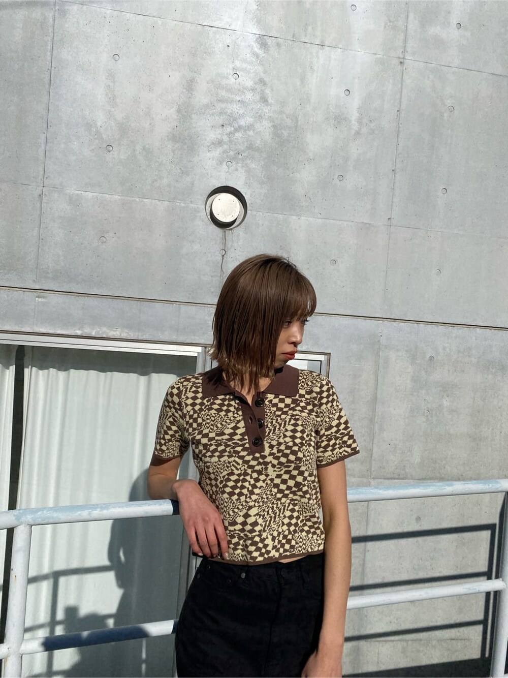 ブラック系のローファー、その他のポロシャツ、ブラック系のデニムパンツを着用したレディースの冬コーディネートの3枚目の写真