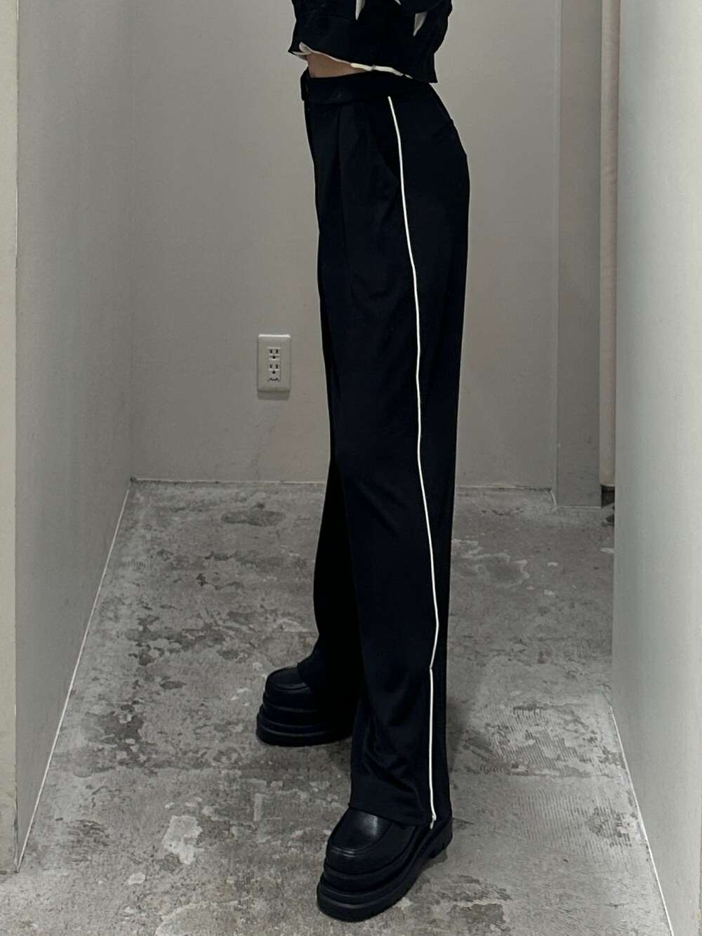 ブラック系のスラックス、ブラック系のニット/セーター、ブラック系のローファーを着用したレディースの冬コーディネートの3枚目の写真