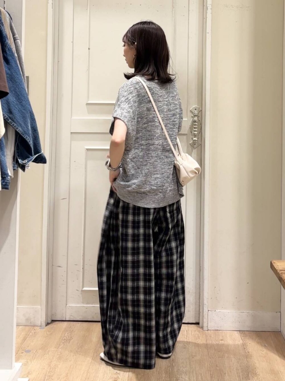 ベージュ系のショルダーバッグ、ホワイト系のパンプス、ホワイト系のタンクトップを着用したレディースの春コーディネートの2枚目の写真