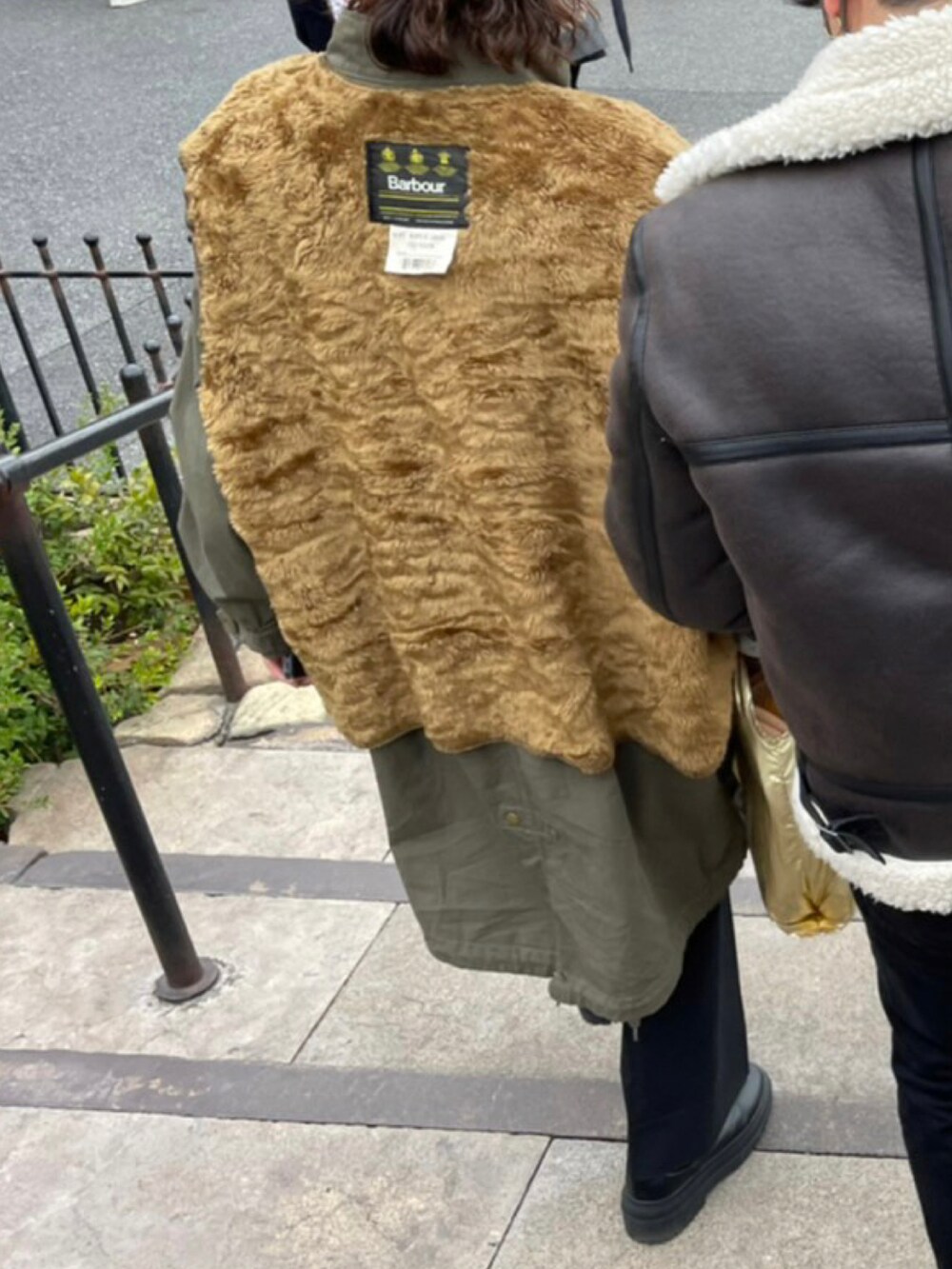 ゴールド系のトートバッグを着用したレディースの冬コーディネートの2枚目の写真