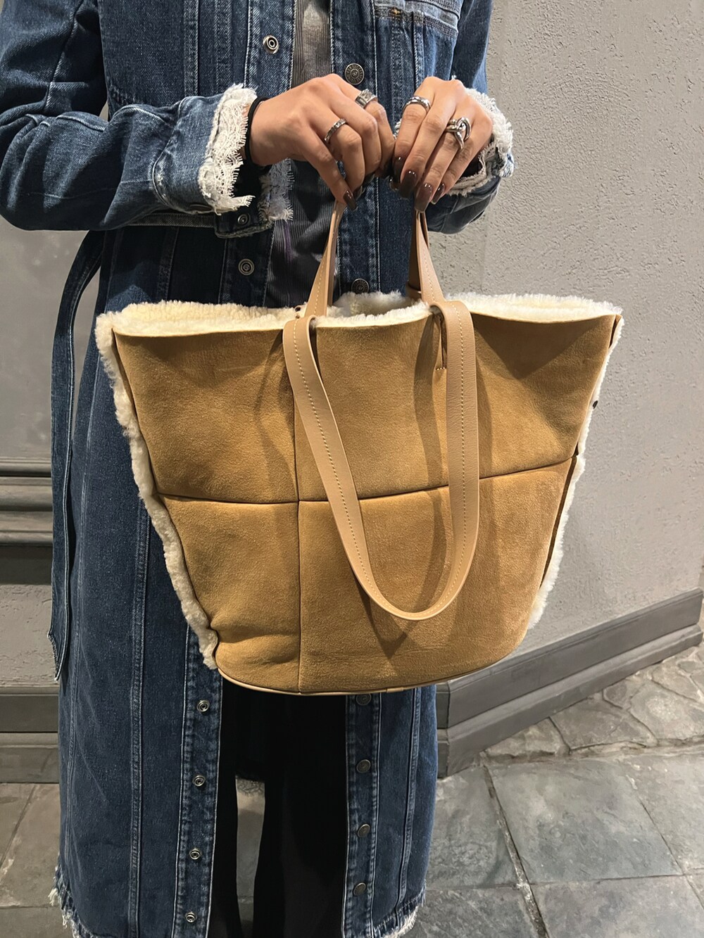 ブルー系のその他トップス、ベージュ系のショルダーバッグ、ブラック系のデニムパンツを着用したレディースの秋コーディネートの3枚目の写真