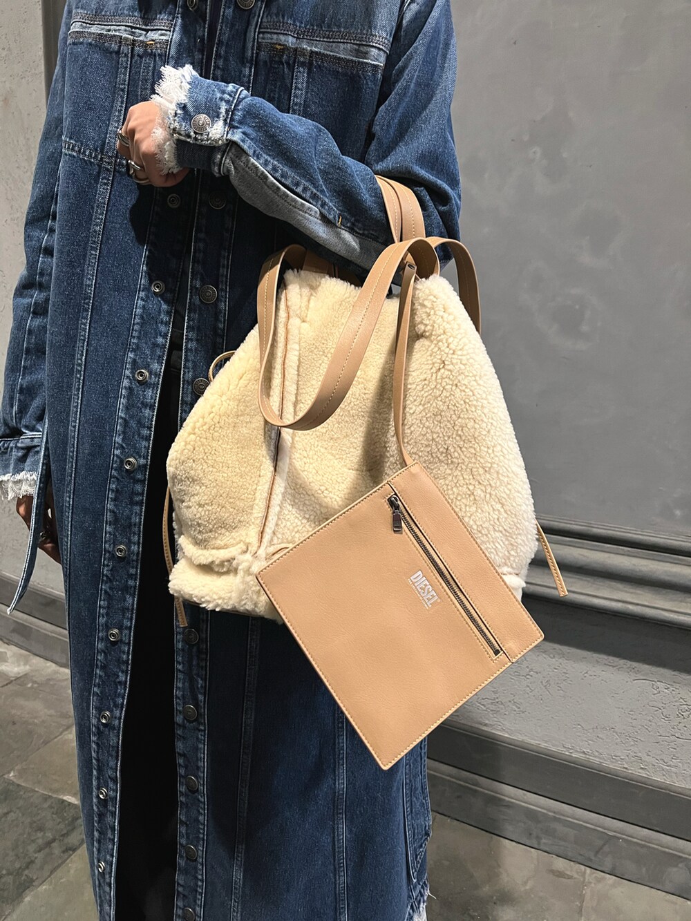 ブルー系のその他トップス、ベージュ系のショルダーバッグ、ブラック系のデニムパンツを着用したレディースの秋コーディネートの2枚目の写真