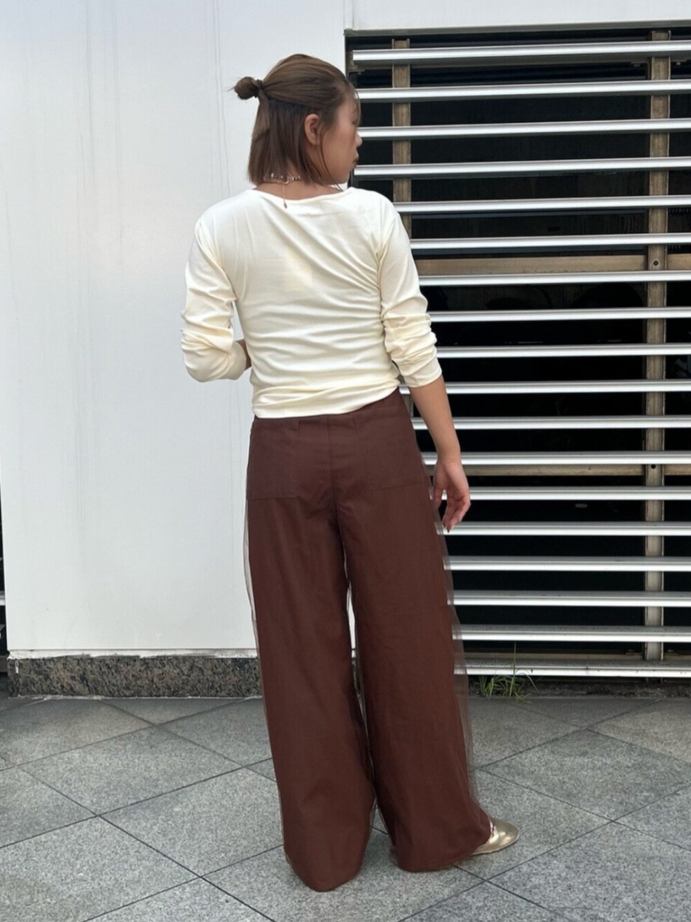 ブラウン系のその他パンツ、ホワイト系のTシャツ/カットソー、ゴールド系のバレエシューズを着用したレディースの秋コーディネートの3枚目の写真