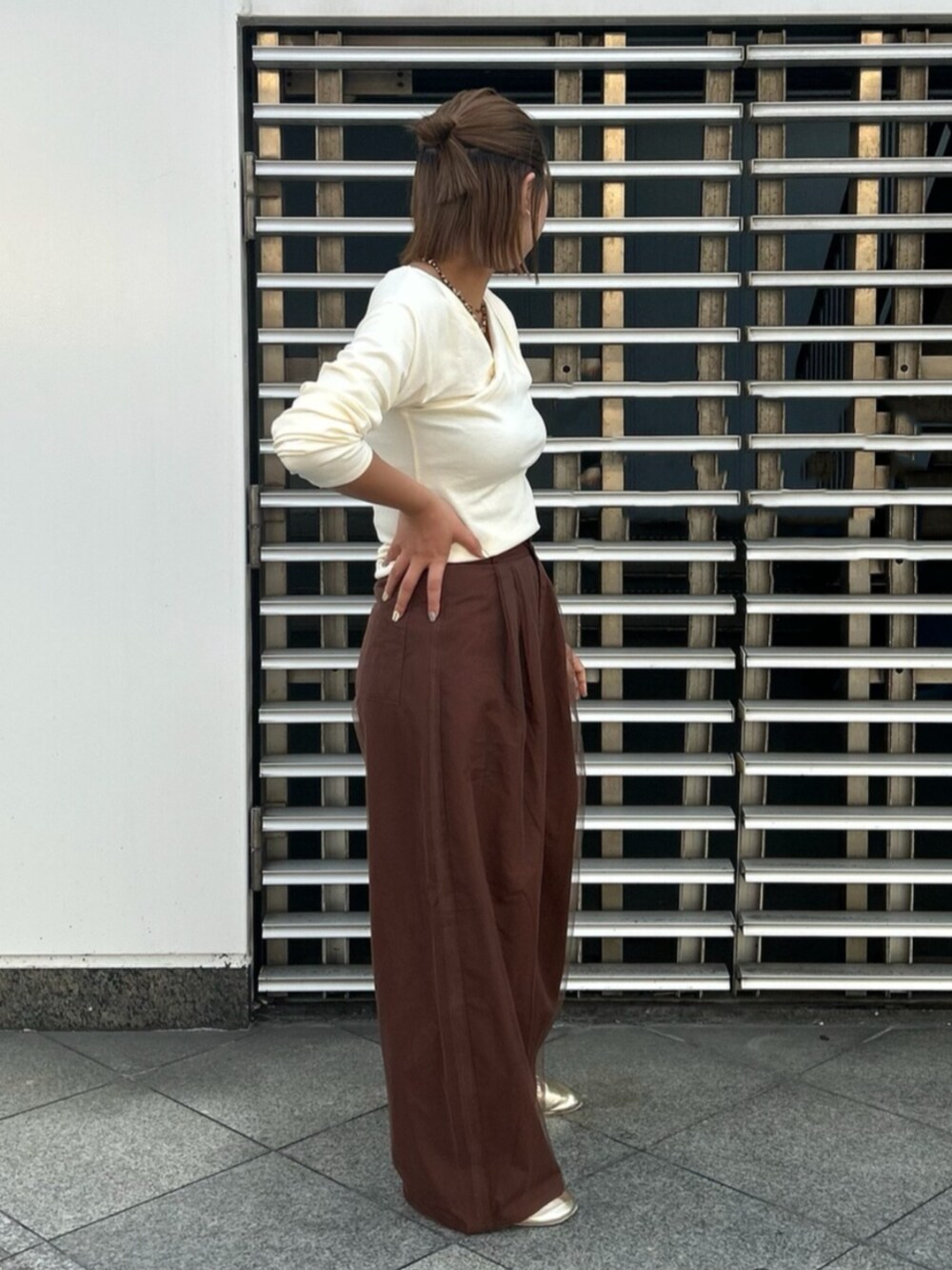 ブラウン系のその他パンツ、ホワイト系のTシャツ/カットソー、ゴールド系のバレエシューズを着用したレディースの秋コーディネートの2枚目の写真