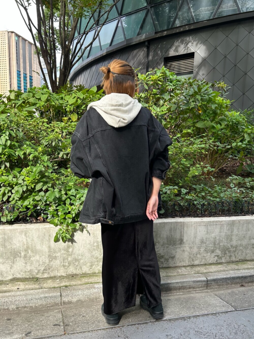 ホワイト系のハンドバッグ、ブラック系のデニムジャケット、ブラック系のスカートを着用したレディースの秋コーディネートの4枚目の写真
