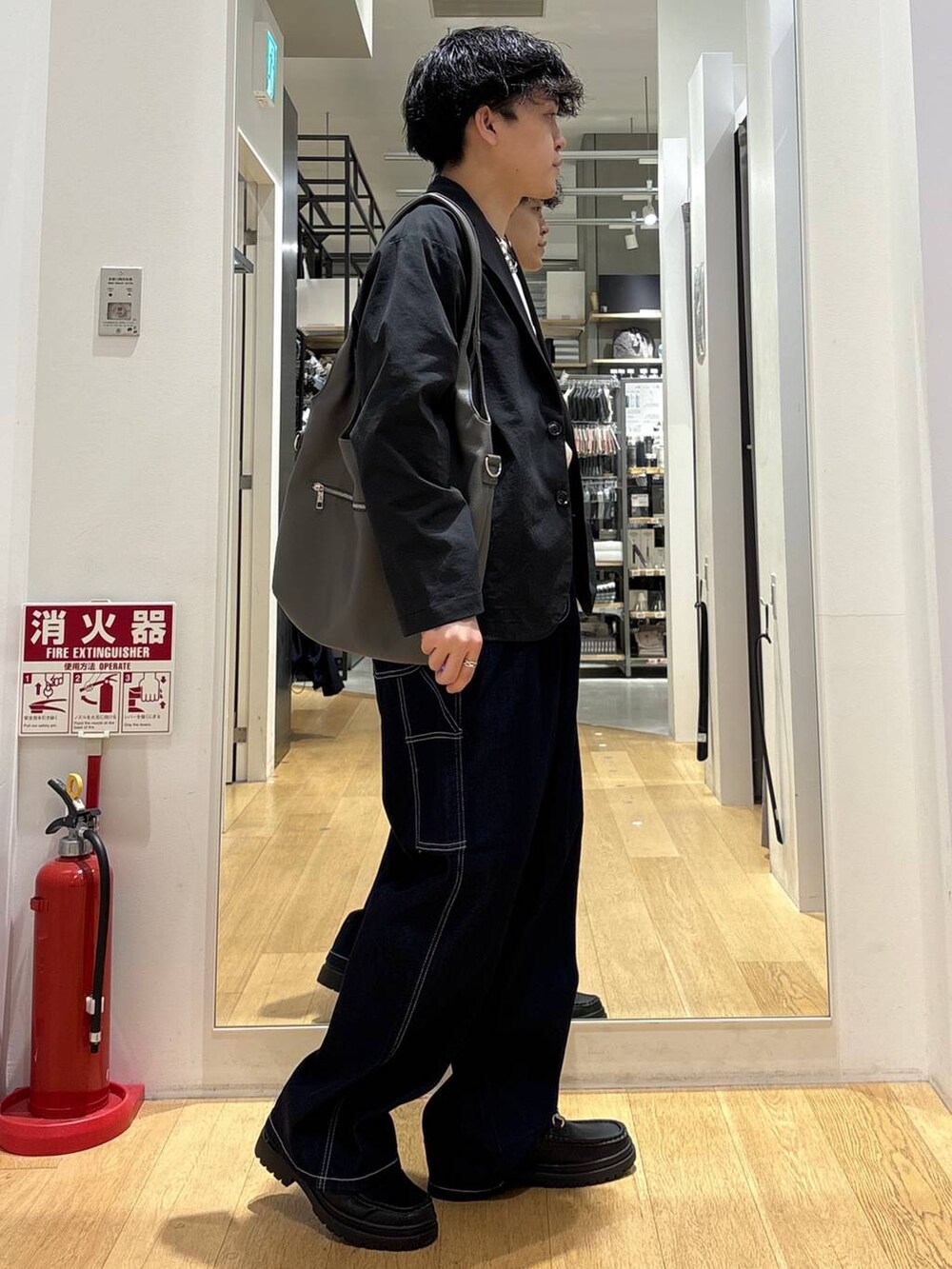 ブラック系のローファー、グレー系のトートバッグ、ホワイト系のTシャツ/カットソーを着用したメンズの春コーディネートの2枚目の写真