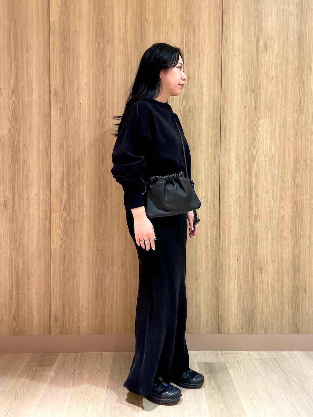 ブラック系のニット/セーター、ブラック系のバッグ、ブラック系のスカートを着用したレディースの冬コーディネートの2枚目の写真