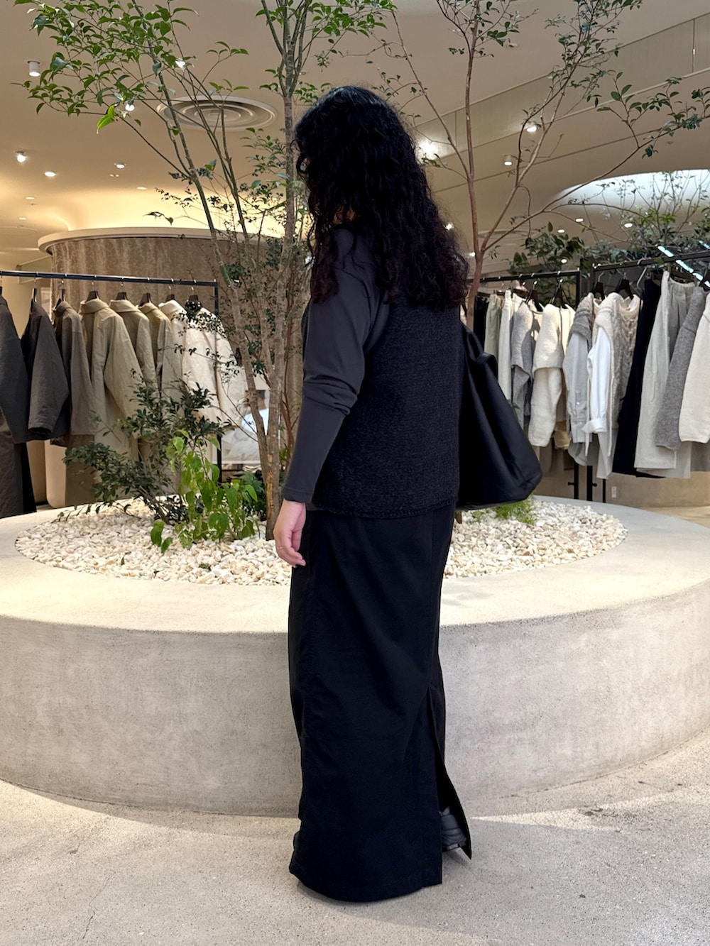 グレー系のTシャツ/カットソー、ブラック系のスカート、ブラック系のトートバッグを着用したレディースの秋コーディネートの4枚目の写真
