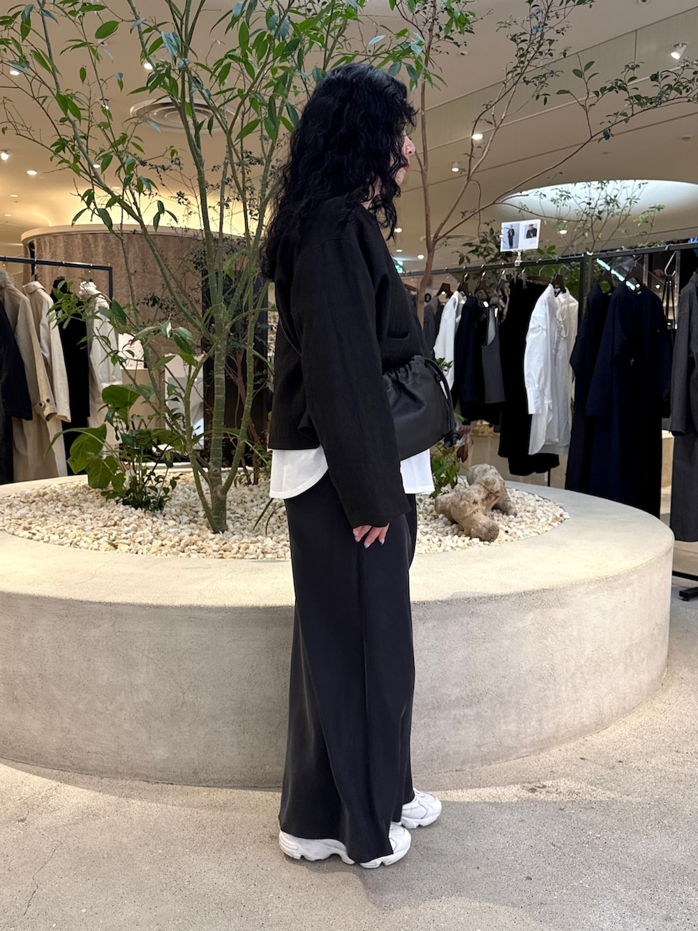 ブラック系のショルダーバッグ、ホワイト系のTシャツ/カットソー、ブラック系のノーカラージャケットを着用したレディースの冬コーディネートの2枚目の写真