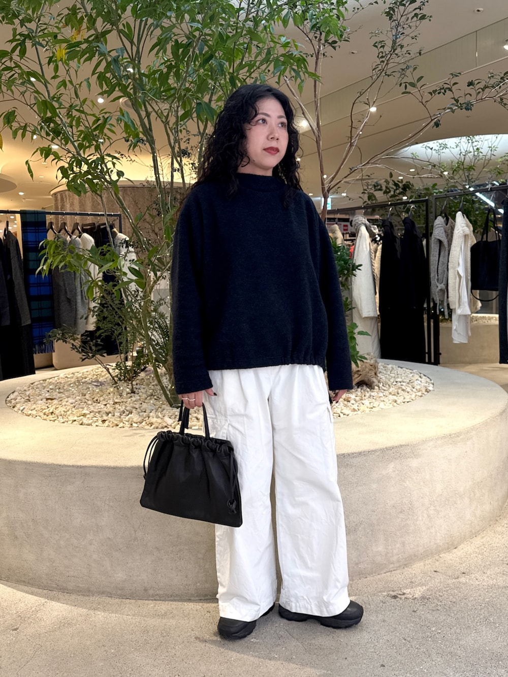 ブラック系のバッグ、グリーン系のステンカラーコート、ブルー系のその他トップスを着用したレディースの冬コーディネートの5枚目の写真