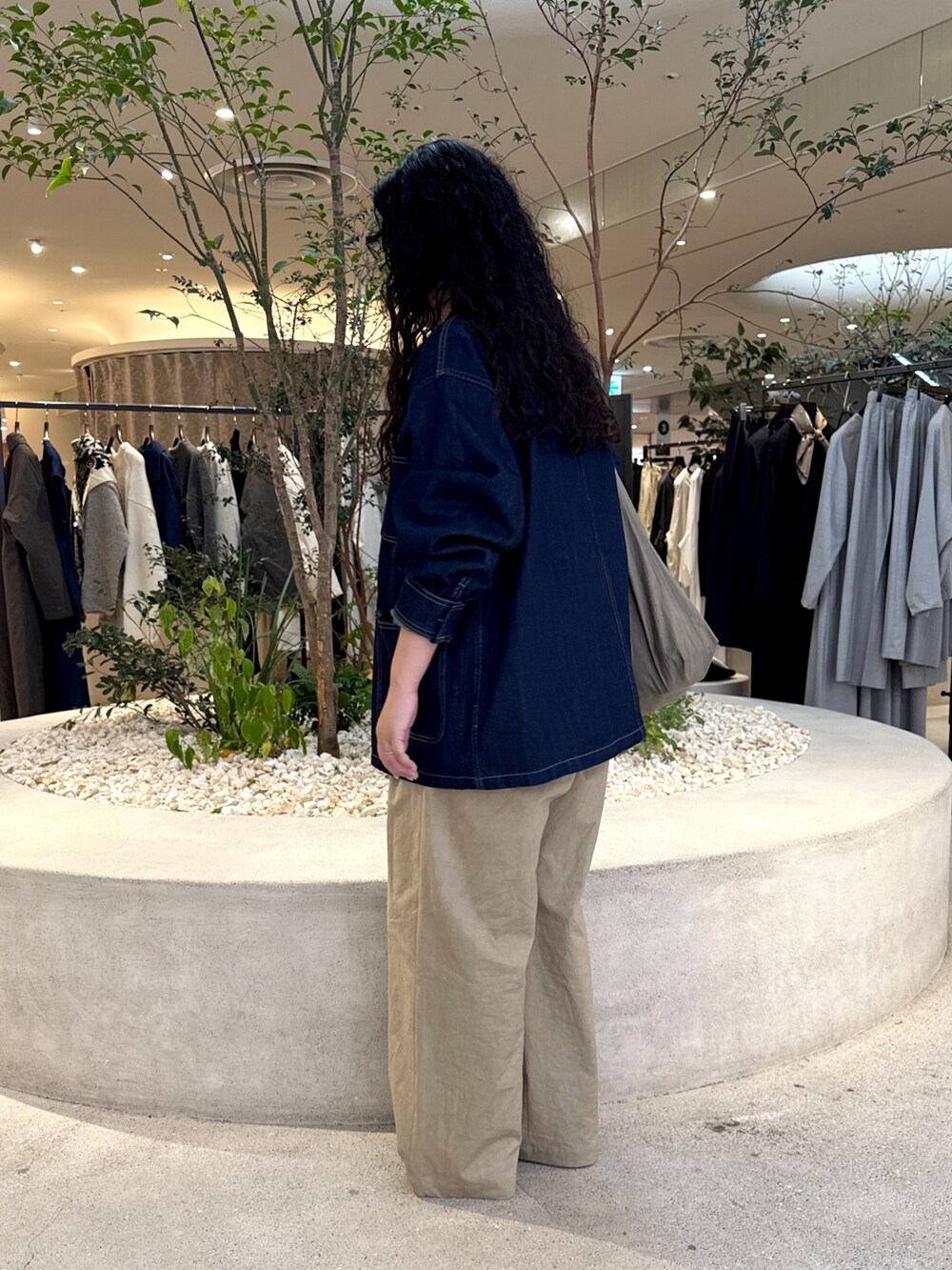 グレー系のショルダーバッグ、ベージュ系のその他パンツ、ブルー系のカバーオールを着用したレディースの秋コーディネートの4枚目の写真