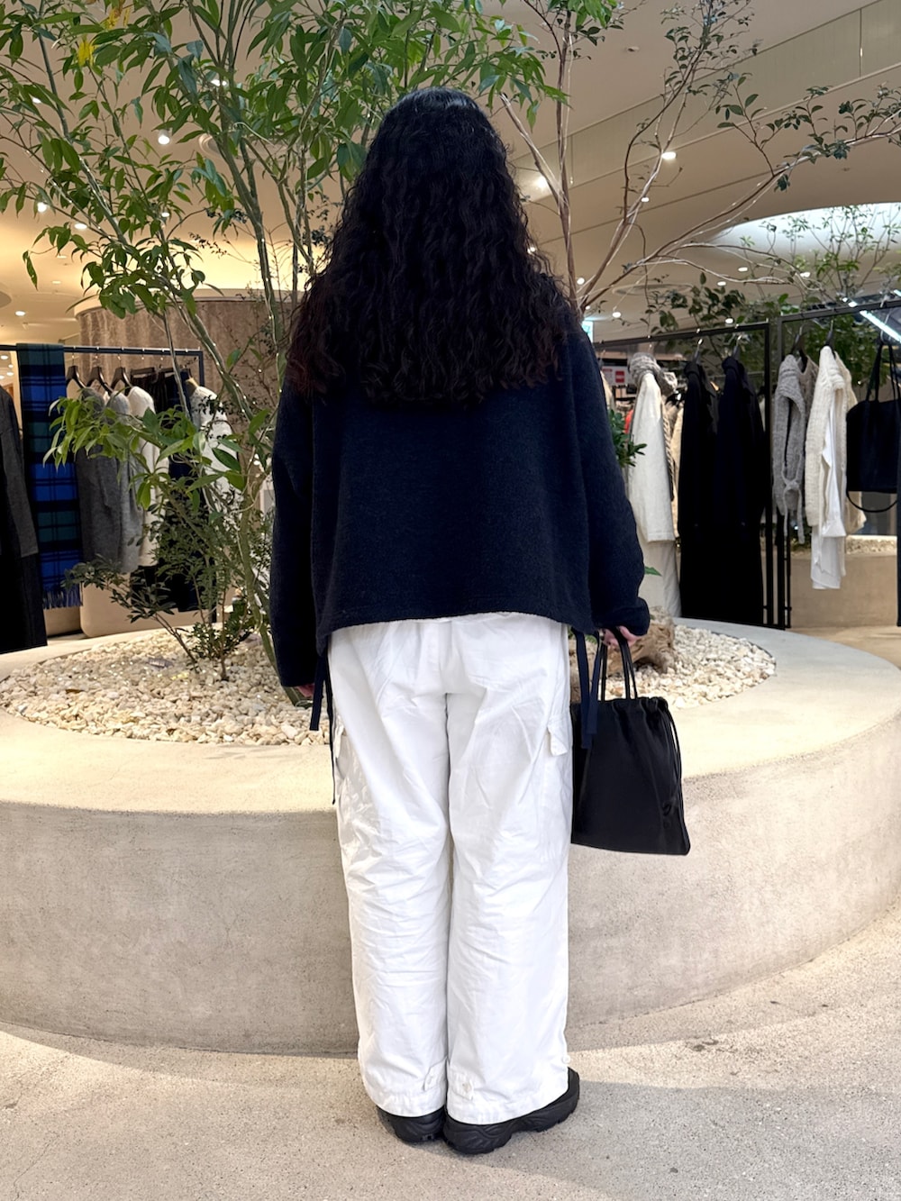 ブラック系のバッグ、グリーン系のステンカラーコート、ブルー系のその他トップスを着用したレディースの冬コーディネートの6枚目の写真