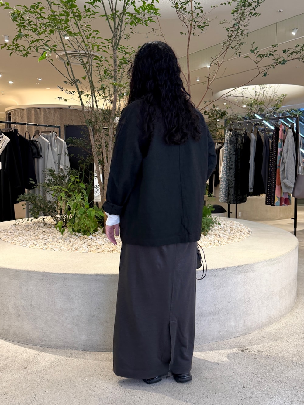 ホワイト系のTシャツ/カットソー、ブラック系のその他アウター、グレー系のスカートを着用したレディースの秋コーディネートの3枚目の写真