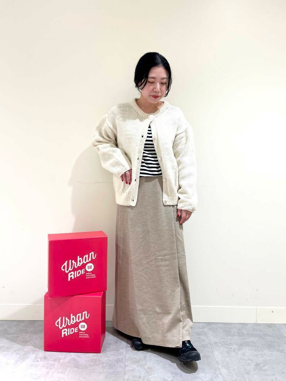 ホワイト系のニット/セーター、ブラック系のTシャツ/カットソー、ベージュ系のスカートを着用したレディースの冬コーディネートの3枚目の写真