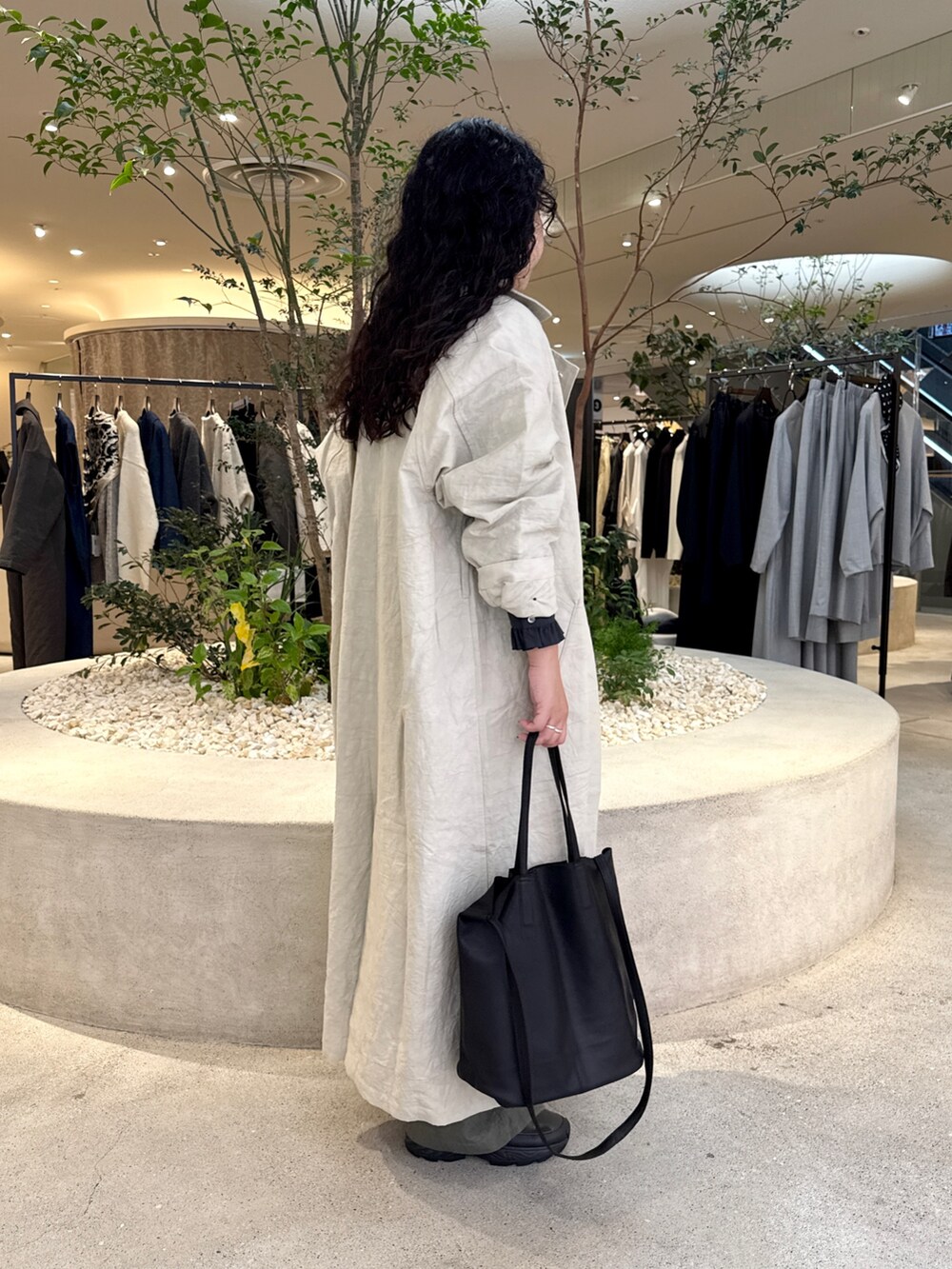 ブラック系のトートバッグ、グリーン系のその他パンツ、ベージュ系のトレンチコートを着用したレディースの秋コーディネートの2枚目の写真