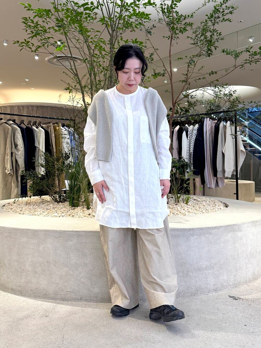 グレー系のニット/セーター、ホワイト系のシャツ/ブラウス、ベージュ系のその他パンツを着用したレディースの春コーディネートの4枚目の写真