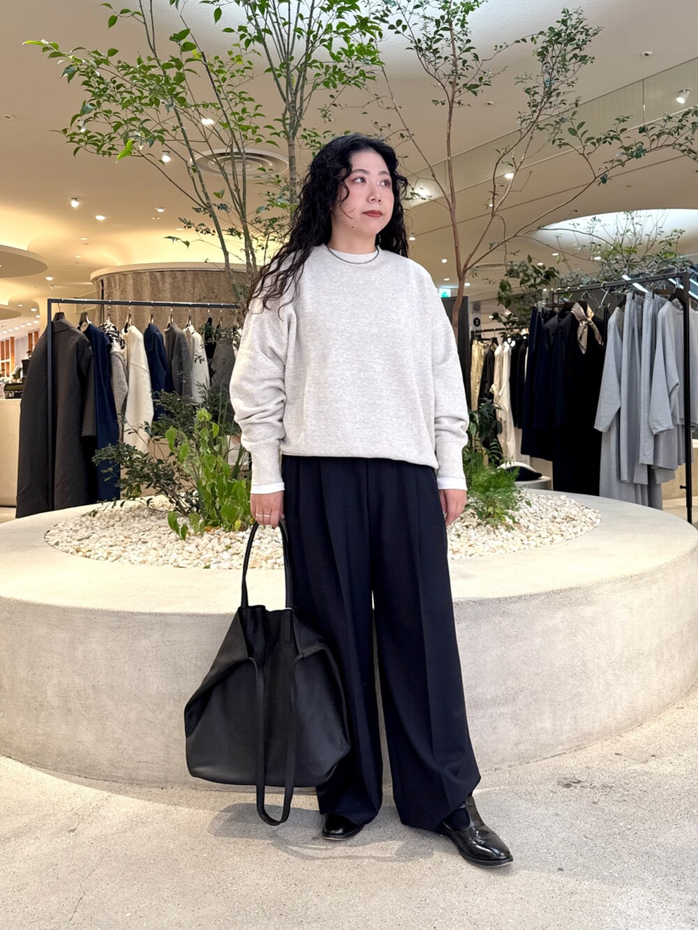 グレー系のスウェット、ホワイト系のTシャツ/カットソー、ブラック系のトートバッグを着用したレディースの秋コーディネートの5枚目の写真