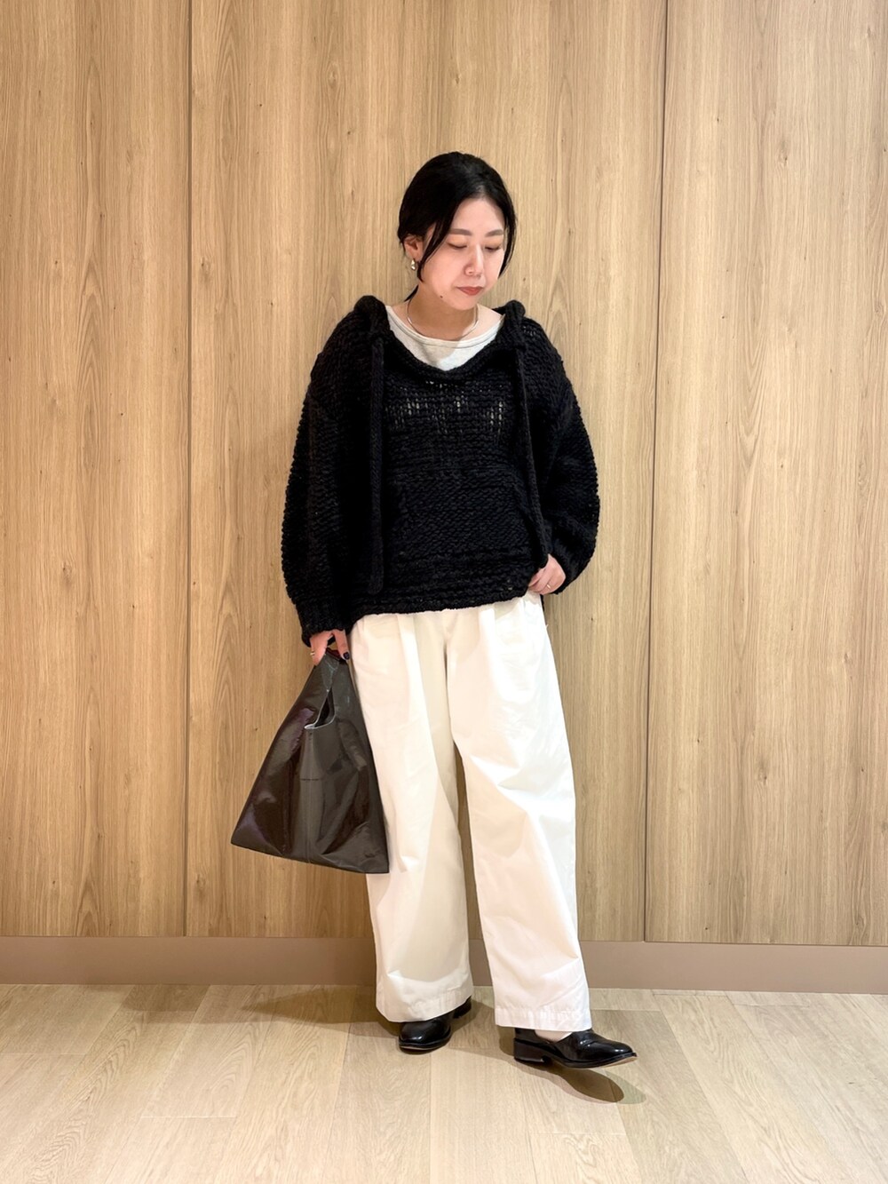 ベージュ系のタンクトップ、ホワイト系のその他パンツ、ブラック系のニット/セーターを着用したレディースの秋コーディネートの2枚目の写真
