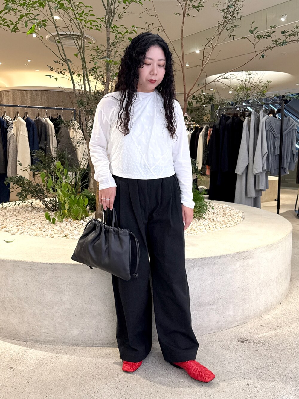 ホワイト系のTシャツ/カットソー、ブラック系のその他パンツ、ブラック系のバッグを着用したレディースの秋コーディネートの5枚目の写真