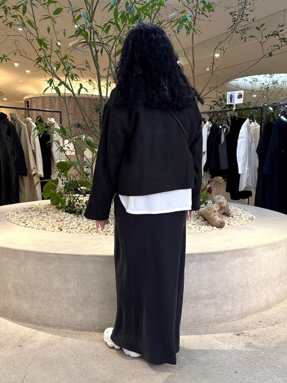 ブラック系のショルダーバッグ、ホワイト系のTシャツ/カットソー、ブラック系のノーカラージャケットを着用したレディースの冬コーディネートの3枚目の写真